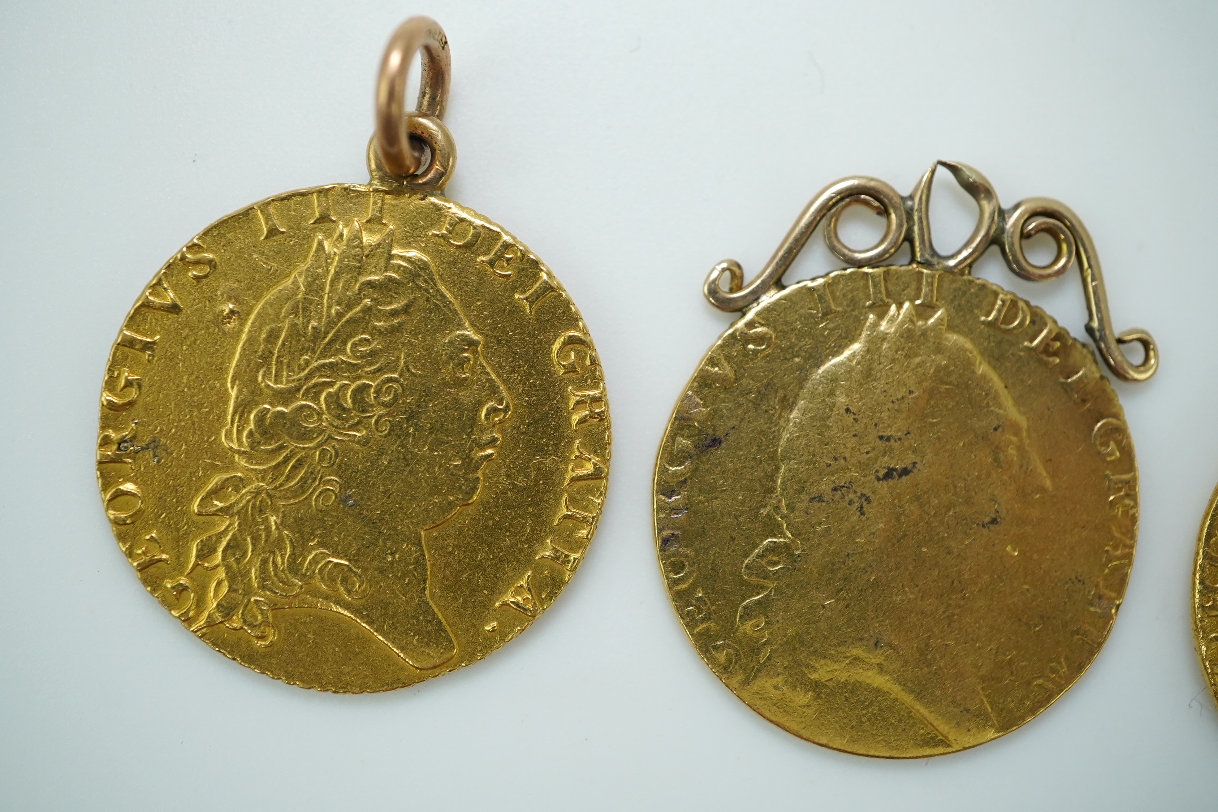 Three George III gold spade guinea coin pendants, late 18th/early 19th century and later